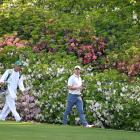 Rory McIlroy and his caddie walk among the famed azaleas at Augusta National during the third...