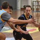 Otago Nuggets guard Darcy Knox looks for a way around Jonathan Janssen (left) and Caleb Smiler at...
