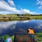 An Environment Southland environmental technical officer measures river flow with an acoustic...