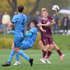 Dunedin City Royals attacker Em Watanabe (second right) has a crack at a bicycle shot on goal...