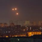 Explosions are seen in the night sky as Ukrainian servicemen fire at a drone during a Russian...