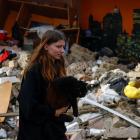 A woman walks with her cat amid the rubble from a Russian drone strike outside Kyiv. Photo: Reuters 
