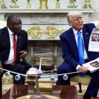 US President Donald Trump shows alleged news reports in a meeting with South African President...