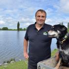 The late Chris Allen, with working dog Ace beside the irrigation lake he created on his farm near...