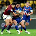 Highlanders first five Taine Robinson tackles Hurricanes loosie Du’Plessis Kirifi during their...