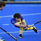 Taieri Tuataras player James Nicolson gives it a good whack while watched by University Panthers...