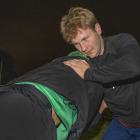 Sports reporter Sam Coughlan grapples with Linwood halfback Ben O’Donovan. Photo: Geoff Sloan