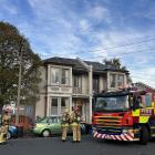 Firefighters gather outside a Leith St student flat  after extinguishing a fire in the kitchen....