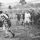 A New Zealand University player (left) about to unload during the team’s rugby match against...