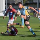 University’s Lanson Randell steps past the tackle of Harbour halfback Tetauru Cuthers, with Toni...