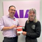 Mark Campbell (right), from the Broken Pistons Motorcycle Club, hands over $500 to Westpac’s Andy...