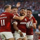 Lions midfielder Bundee Aki celebrates with team-mates after scoring a try in the test against...