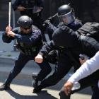 Members of the Los Angeles Metro Police clash with demonstrators during a protest against federal...