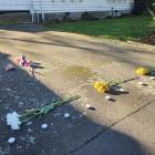Flowers and candles laid on the driveway of a property on Gracefield Ave, where police found...