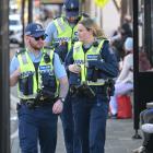 Police scan the bus hub in Great King St, Dunedin, on Friday, after reports of a man with a...
