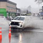 A ute is driven through pooling water in a trouble spot in Anzac Ave following persistent rain...