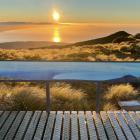 The sun sets over the Hump Ridge Track, which  weaves through native forest, sub-alpine ridges...