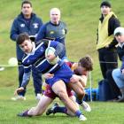 Kaikorai winger Rico Fisher gets brought down in a tackle by Alhambra-Union’s Charles Alston...