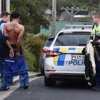 A gardener being handcuffed after he was spotted carrying a machete in Opoho yesterday. Photo:...