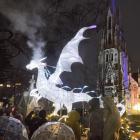 A glowing dragon exhales a smoke cloud over visitors eagerly waiting to be let into the Dunedin...
