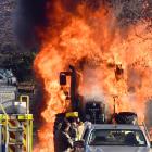 A hedge-cutting tractor is engulfed in flames in Three Mile Hill Rd yesterday. Photos: Stephen...