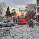 First-responders gather outside a building that was hit by an Israeli strike in Tehran on Friday,...