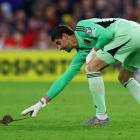 Belgium goalkeeper Thibaut Courtois tries to catch a rat that ran on to the pitch during his side...