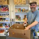 Presbyterian Support Otago Family Works Foodbank co-ordinator Adam Doesburg loads up a box of...