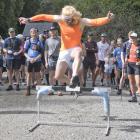 ‘‘Multisport’’ athlete Pascal Saker leaps over a hurdle at the start of the Crush the Cargill...
