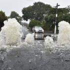 Water gushes from a manhole cover in Forbury Rd near Hillside Rd on Tuesday. PHOTO: GREGOR...