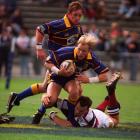 Highlanders winger Jeff Wilson has flanker Paul Henderson in support as he tries to elude Reds...