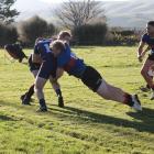 Owaka defenders Josh Huddleston (left) and Chris Chittock stop West Taieri winger Jacob Walls...