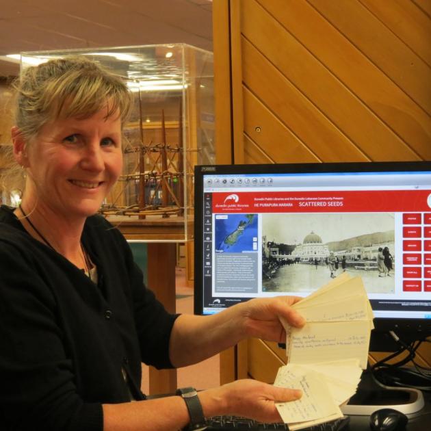 Emma Milburn shows the old index cards, which Dunedin Public Libraries has  begun to digitise, in front of the  recollect home page where the archived material will be able to be  accessed. Photo by Joshua Riddiford