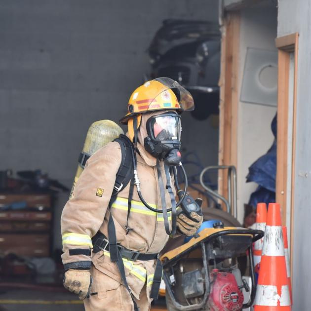 A firefighter attends a blaze at a South Dunedin workshop. Photo by Gregor Richardson.