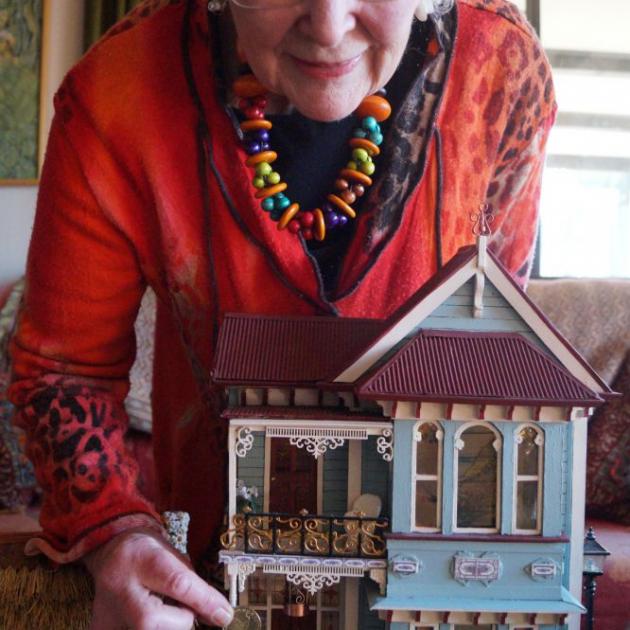Miniature creator and collector Margaret Lindsay holds a $2 coin for scale against her model of 178 Queen St. PHOTOS: GRETA YEOMAN