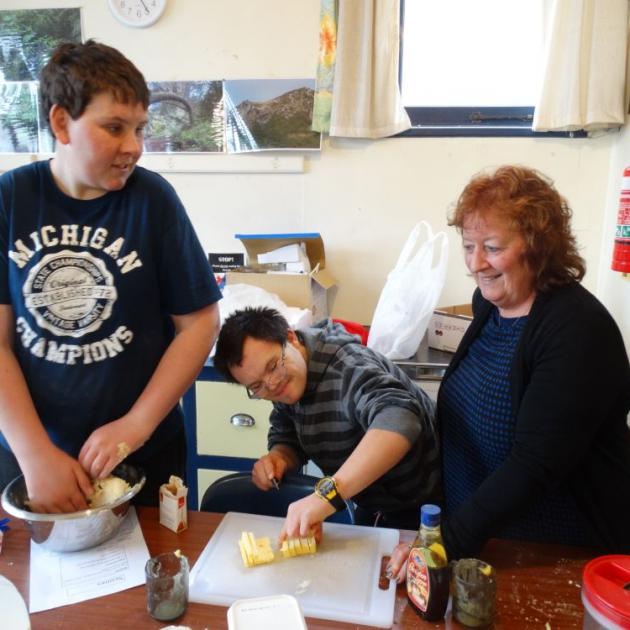 From left: Josh Anderson (19) and Rhys Walsh (21) mix up a batch of date scones with Sara Cohen principal Raewyn Alexander. PHOTO: ELEANOR AINGE ROY 