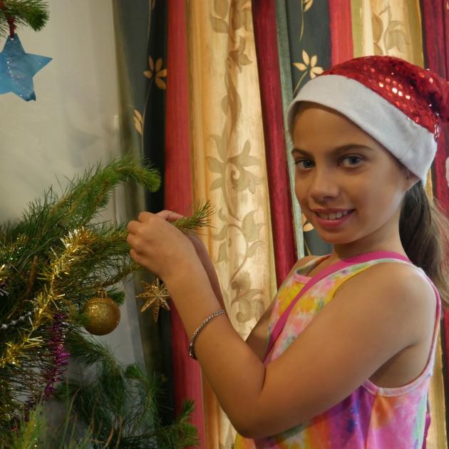Ariah Gillon-Smith adds a  star decoration to her family’s Christmas tree. PHOTO: JESSICA WILSON...