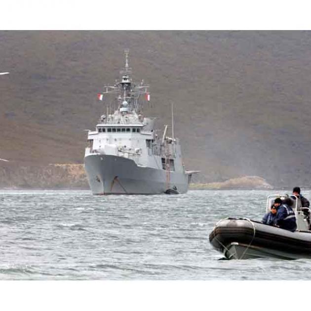 A Seasprite helicopter from New Zealand frigate HMNZS Te Kaha ferries sections of boardwalk on to...