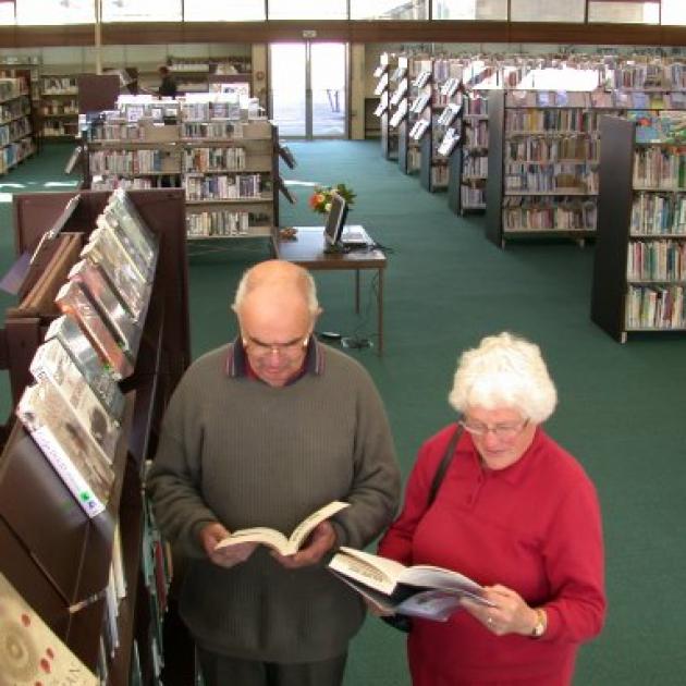 Bernard and Anna Wilkinson check out new books at newly reopened Oamaru Library. Photo by David Bruce.