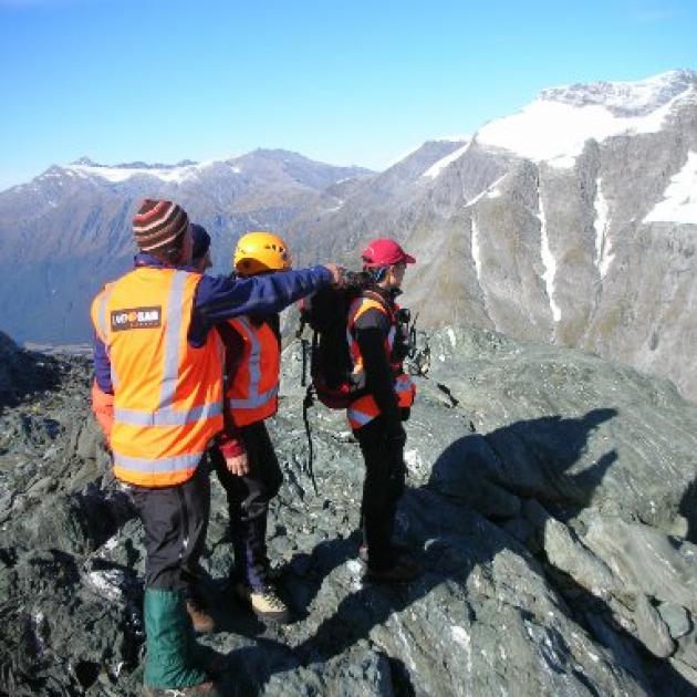 Rescue searchers Alan Gillespie (left), John Taylor, Rod Walker and Emma Fleming survey an area of Mt Aspiring.  Photo by Landsar Wanaka/Cameron Mulvey