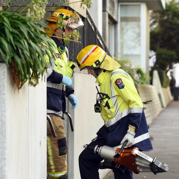 A firefighter carries cutting equipment into Dunedin Hospital after a man was stuck in an X-ray machine in 2017. Photo: Stephen Jaquiery