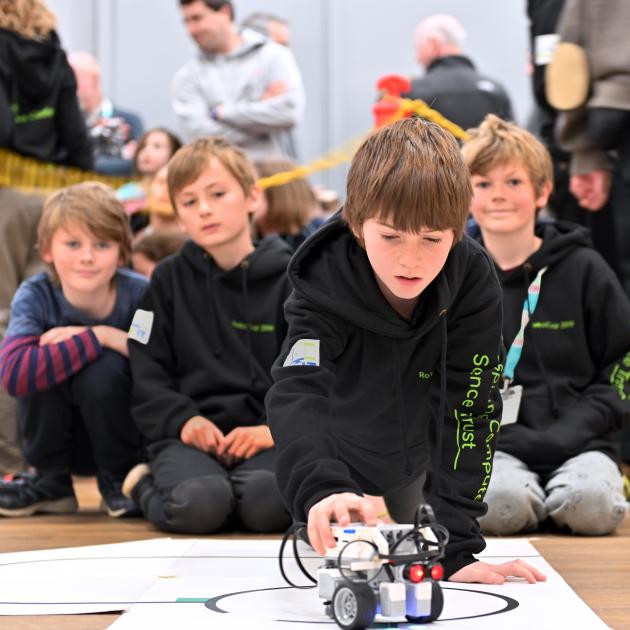 Wanaka Primary School pupil Jacob Gould (10) makes an adjustment to the robot built by fellow...