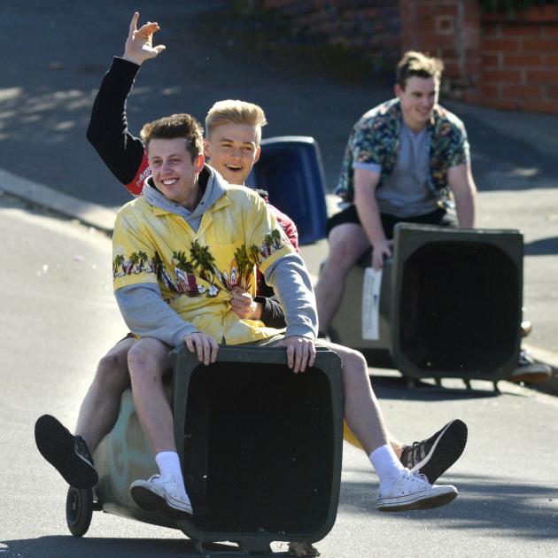 Young party-goers ride down Union St on a wheelie bin before Dunedin police arrived to put an end...