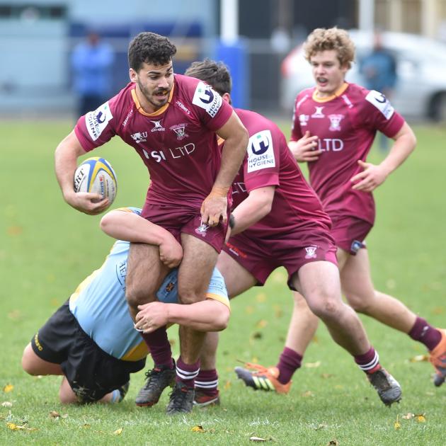Alhambra-Union second five-eighth Legin Hotham stands in a tackle from University prop Mamea...