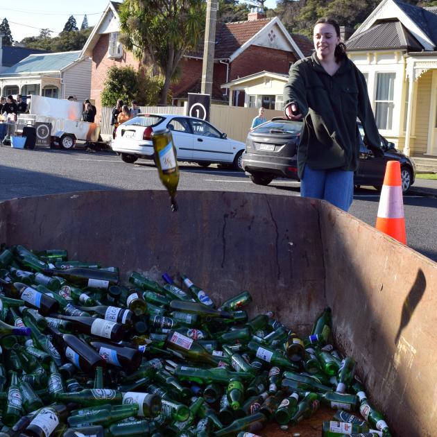 University of Otago student Kasie Jopp (19) throws a bottle in a skip during Sustainability Week...
