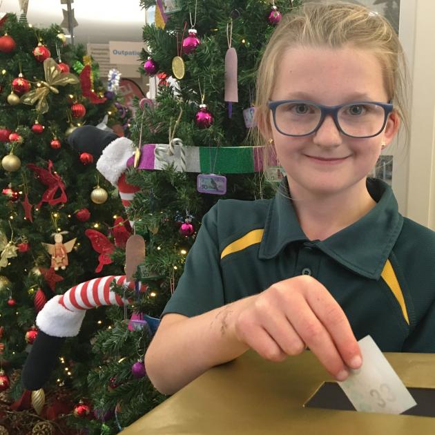 Emma Corson (9) votes for her favourite Christmas tree after admiring the 14 on display at...