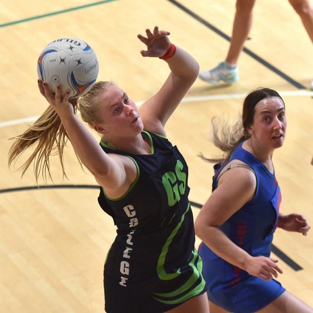 College attacker Ivy McLean grabs the ball watched by Uni Albion A defender Bree Andrews at the...