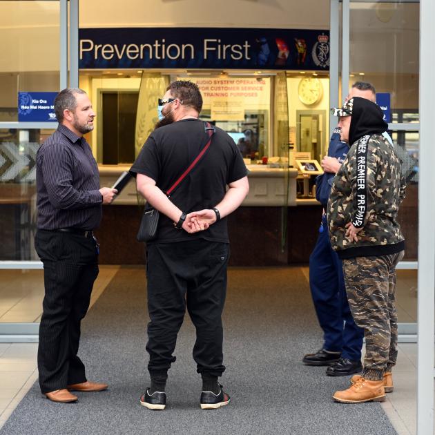 Wanted man James Bryant (centre) is arrested by a Dunedin police officer (left) after handing...