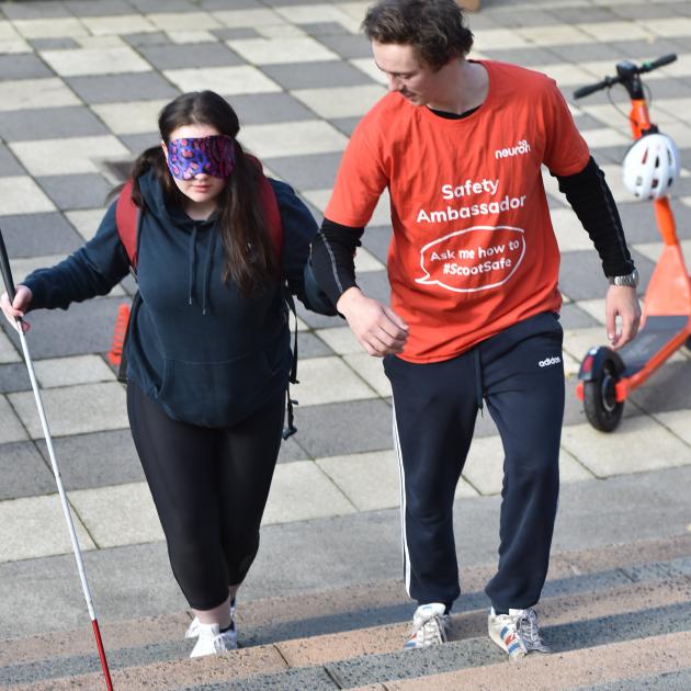 Nursing student Catherine Nichol is guided around a visual impairment obstacle course by Neuron...