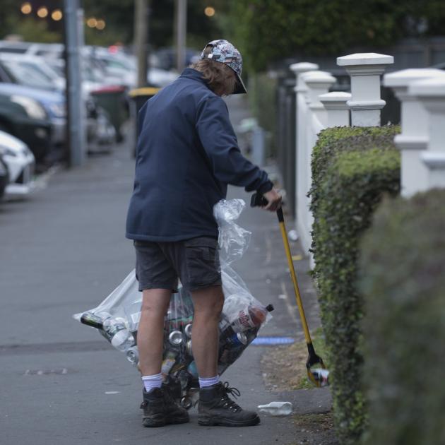 A University of Otago employee picks up rubbish around university owned flats in Castle St...
